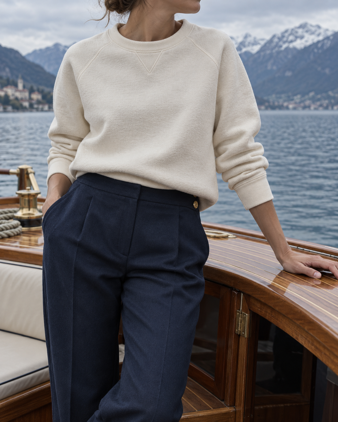 Cremefarbener Pullover und navyblaue Hose auf einem klassischen Boot